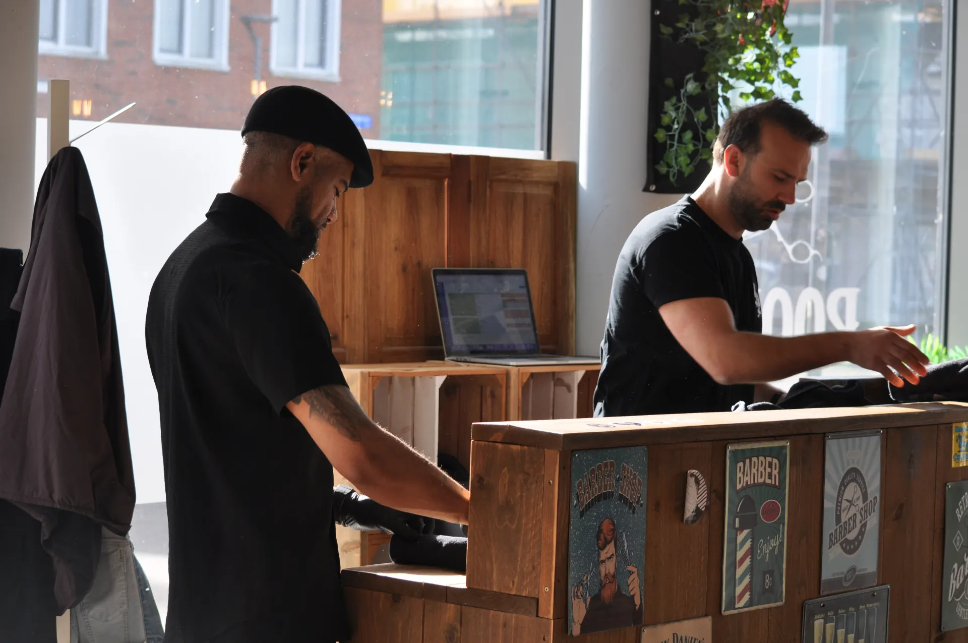 Barbers aan het werk achter de toonbank van Barber Poort in Almere Poort